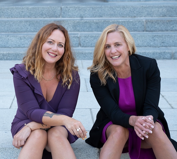 Jennifer and Katie sitting while smiling